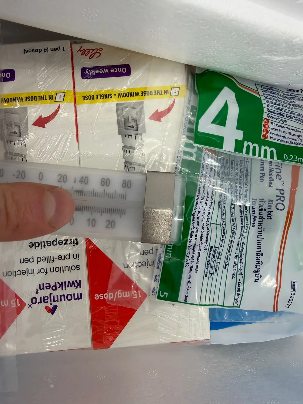 Temperature check of an authentic Mounjaro KwikPen against a fridge thermometer, inside the 2–8°C (36–46°F) cold-chain range, at the TRT Bangkok Clinic in Pattaya