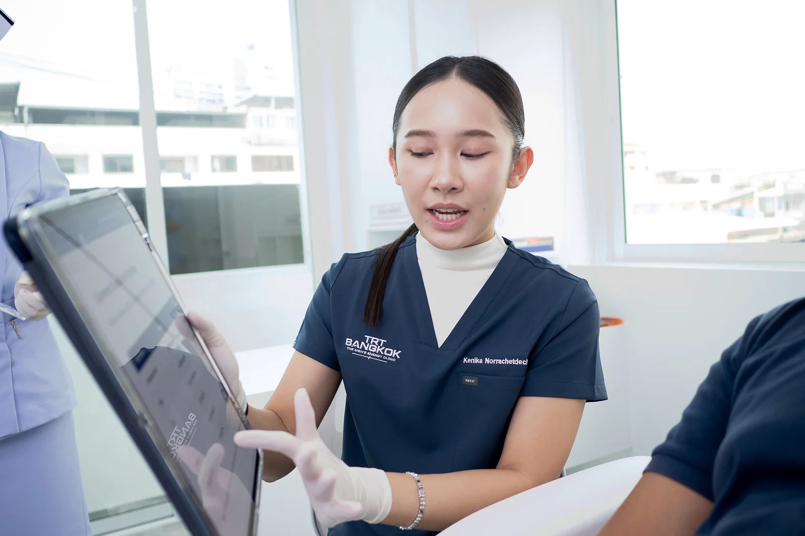 Dr. Kenika explaining personalized GLP-1 weight-loss treatment plan on tablet during consultation at TRT Bangkok